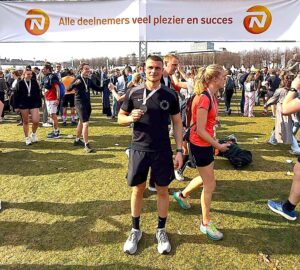 F3 Fysio therapeut houdt zijn medaille omhoog na de NN Rotterdam Marathon