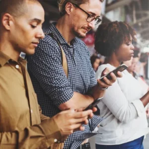 Mensen kijken langdurig op hun telefoon op het perron – verhoogd risico op technek en nekklachten.