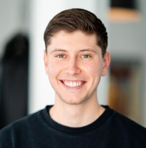 Een lachende man draagt een zwart Nike-sweatshirt met Fit Food Focus-logo bij F3 Fysio