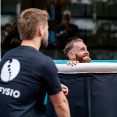 Man zit in een ijsbad van F3 fysio onder begeleiding van een ijsbadmeester voor de opening van de nieuwe vestiging op de Mariniersweg te Rotterdam