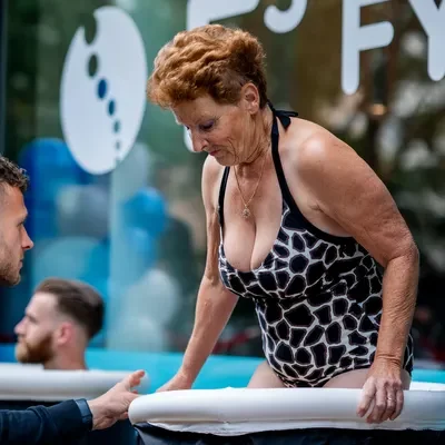 Vrouw in badpak stapt in ijsbad voor de deur van de nieuwe vestiging van F3 Fysio
