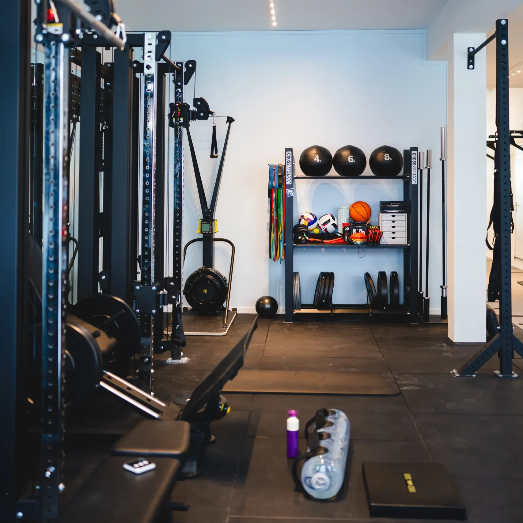 Moderne fitnessruimte met kettlebells, gewichten, weerstandsbanden, een sandbag en fitnessapparaten.