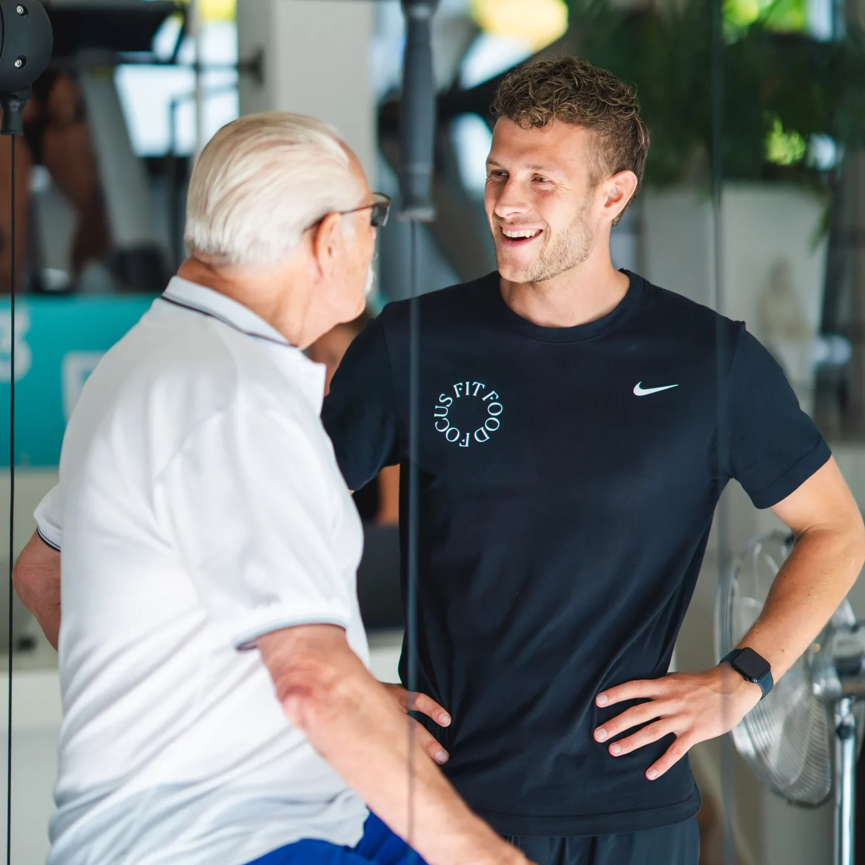 Fysiotherapeut van F3 Fysio in gesprek met een oudere cliënt over knieklachten en mogelijke behandeling bij knie-artrose.