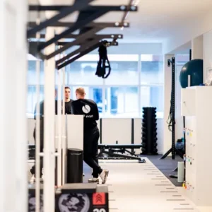 F3 fysiotherapeuten staan te praten in moderne trainingsruimte van de vestiging op de mariniersweg te Rotterdam