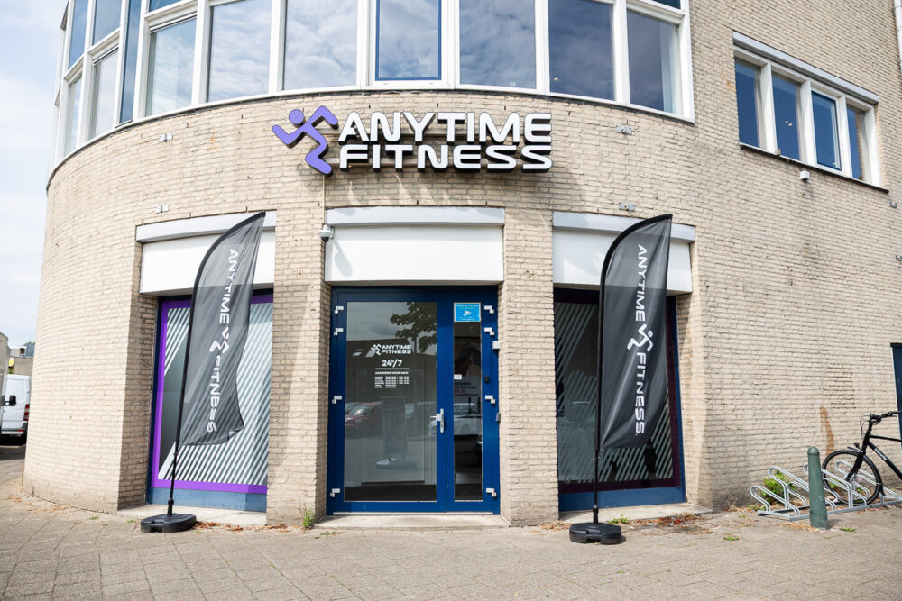 De ingang van Anytime Fitness met vlaggen