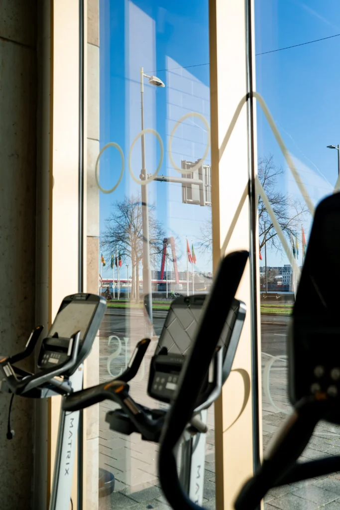 Cardiofitnessapparaten bij de grote ramen van F3 GYM Hertekade Rotterdam, met uitzicht op de stad